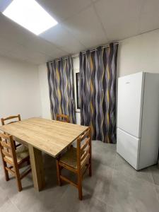 ElmasCasa Ilaria的厨房配有木桌和冰箱。