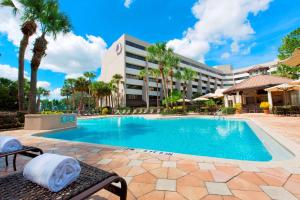 奥兰多奥兰多迪斯尼泉希尔顿逸林套房酒店的棕榈树度假村的游泳池以及大楼