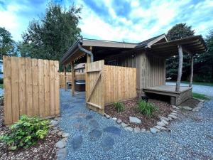 布赖森城Blissful Nook Tiny Home ~ Cozy Retreat w/ Hot Tub; near Town and Deep Creek的木棚,带长凳和围栏