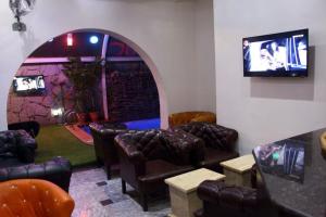 阿布贾E-Suites Hotel, Abuja的一间设有皮椅和电视的等候室