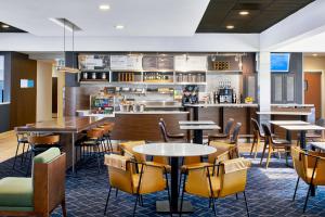 孟菲斯孟菲斯机场万怡酒店的一间带桌椅的餐厅和一间酒吧