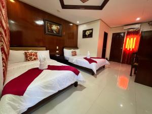 公主港马里亚菲酒店的一间卧室配有两张红色和白色床单