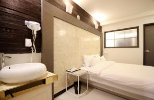 釜山Bandal Hotel的带浴缸、床和盥洗盆的浴室
