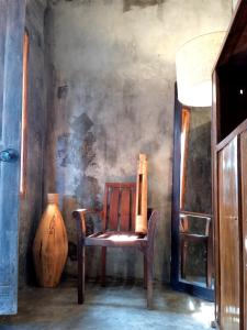 登巴萨Classic Local House Grenceng的木椅和花瓶
