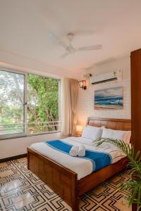 果阿旧城HideAway 1BHK, Parra, North Goa (STU)的一间卧室设有一张床和一个大窗户