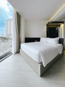 胡志明市The Concept Hotel HCMC- District 1的窗户客房内的一张大白色床