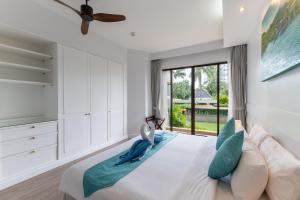 邦涛海滩Allamanda Laguna Phuket的白色的卧室设有一张大床和一个窗户
