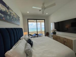 西湾Luxury Ocean front SeaDreams 2 with 7 Mile Beach Views的一间卧室配有一张床,享有海景