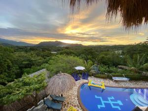 埃尔扎伊诺Quetzal Dorado Eco-Lodge的一个带游泳池和椅子的度假村,享有日落美景