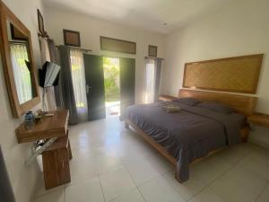 乌鲁瓦图阿莎娜酒店的卧室配有一张床、一张书桌和窗户。