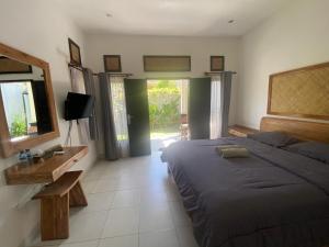 乌鲁瓦图阿莎娜酒店的一间卧室配有一张床、镜子和电视