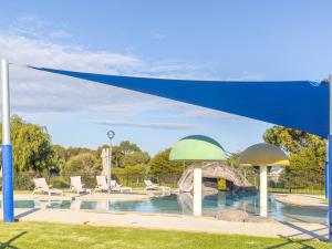 沃纳姆堡NRMA Warrnambool Riverside Holiday Park的游泳池上方的蓝色和绿色天篷