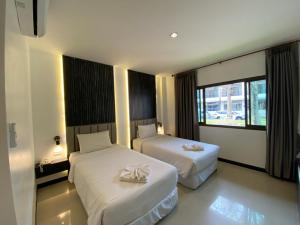 乌隆他尼President Hotel Udonthani的酒店客房设有两张床和窗户。