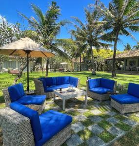 乌纳瓦图纳Elysium的庭院配有蓝色的椅子和遮阳伞。