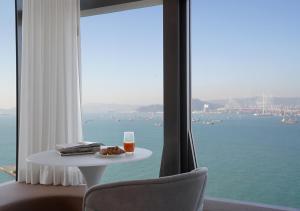 香港One-Eight-One酒店及服务式住宅的一张桌子,上面放着一杯橙汁,书和窗户