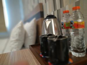 塞尔蓬All Nite and Day Hotel Alam Sutera的咖啡壶和桌子上的两瓶水