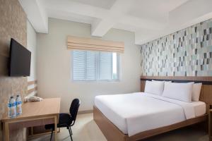 塞尔蓬All Nite and Day Hotel Alam Sutera的卧室配有白色的床、书桌和窗户。