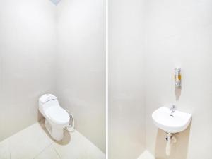 棉兰Sg Premium Guest House By Helocus的白色的浴室设有卫生间和水槽。