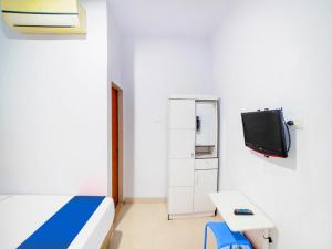 棉兰Sg Premium Guest House By Helocus的一间医院间,配有床和电视