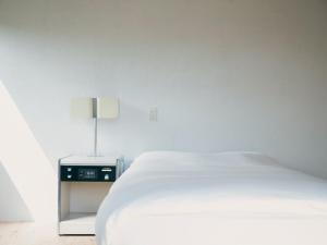 Shimo-ōzu范冰冰 ファン・ビンビン的一间白色卧室,配有床和床头柜