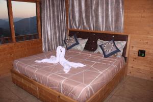 TisaHotel Mannat Sach Pass的一间卧室配有一张带白色毛巾的床