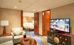 宁波宁波华侨温德姆至尊豪廷大酒店的带电视的客厅和配有床的房间