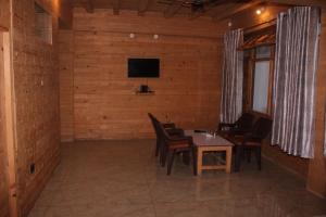 TisaHotel Mannat Sach Pass的一间带桌椅和电视的用餐室