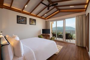 MarchulaWelcomhotel By ITC Hotels, Jim Corbett的一间带一张白色大床的卧室和一个阳台