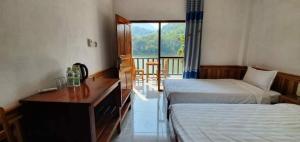 NongkhiawNongkhaiw river view的酒店客房设有两张床、一张书桌和一个窗户。