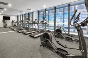 墨尔本Meriton Suites King Street Melbourne的健身房的一排有氧运动器材