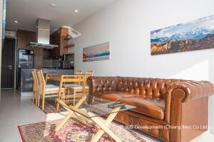 罗勇Escape Condominiums Beachfront Suites - Mae Phim的客厅配有真皮沙发和桌子