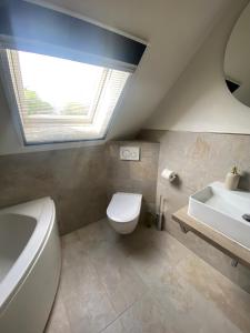 DrachenbronnLa Maison des Roses的浴室配有白色卫生间和盥洗盆。
