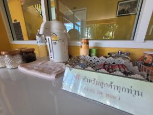 Amnat Charoenโรงแรมบ้านเปรมศิริ的一个带搅拌机的柜台和盒子