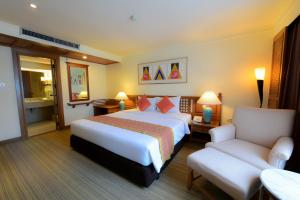 曼谷Silom Serene A Boutique Hotel - SHA Extra Plus的配有一张床和一把椅子的酒店客房