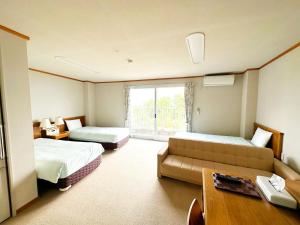 京丹后市森林公園スイス村 風のがっこう京都的酒店客房,设有两张床和一张沙发