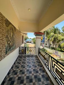 Jothi Cottage -HomeStay的阳台享有带 ⁇ 形地板的房屋的景致。