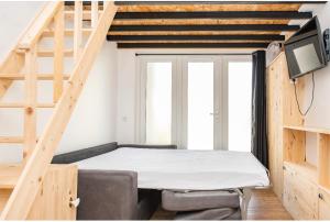 洛特河畔的维伦纽夫Villa des palmiers, Studio cosy的小房间设有床铺和电视