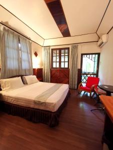 西必洛西必洛森林度假村的一间卧室配有一张床和一张红色椅子
