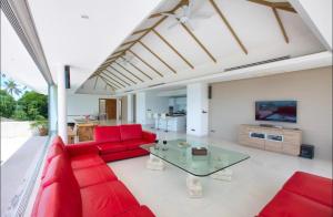 苏梅岛White Tiger Villa的客厅配有红色的沙发和玻璃桌