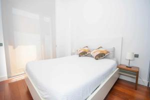马德里Chueca Gran Via Recoletos Libertad 24 2的一张白色的床,上面有两个枕头