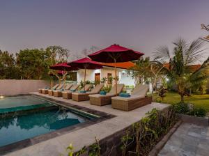 蓝梦岛Nusa Indah Onai Hotel的房屋旁的游泳池配有椅子和遮阳伞