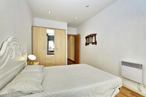 赫罗纳Apartament Sant Feliu的白色的卧室设有一张大床和一个窗户
