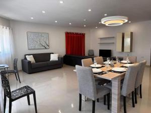 马尔萨什洛克Cozy, Spacious 3 Bedroom Maisonette, 6 to 9 ppl, 1 min walk from Seafront的用餐室以及带桌椅的起居室。