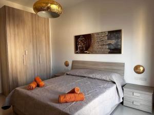 马尔萨什洛克Cozy, Spacious 3 Bedroom Maisonette, 6 to 9 ppl, 1 min walk from Seafront的一间卧室配有带橙色毛巾的床