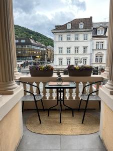 海德堡丹纳酒店的阳台配有桌椅,设有建筑