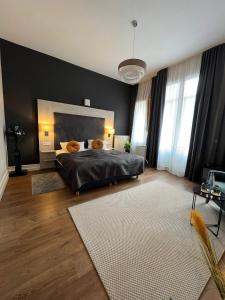 海德堡丹纳酒店的一间卧室设有一张大床和黑色的墙壁