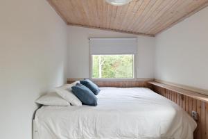 EnkärretFamily Holiday Home in Ingarö的卧室配有带蓝色枕头的大型白色床