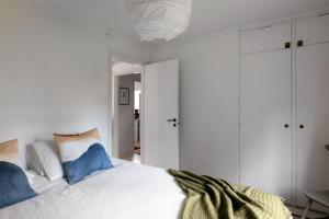 EnkärretFamily Holiday Home in Ingarö的一间卧室配有白色床和蓝色枕头