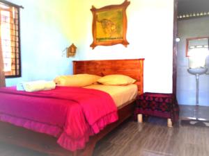 特特巴图Ariel Bungalow Tetebatu的一间卧室配有一张带红色毯子的大床