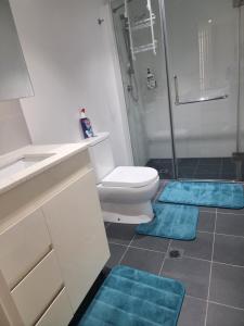 悉尼Parramatta Shared Apartment的浴室设有卫生间和蓝色垫子,位于地板上